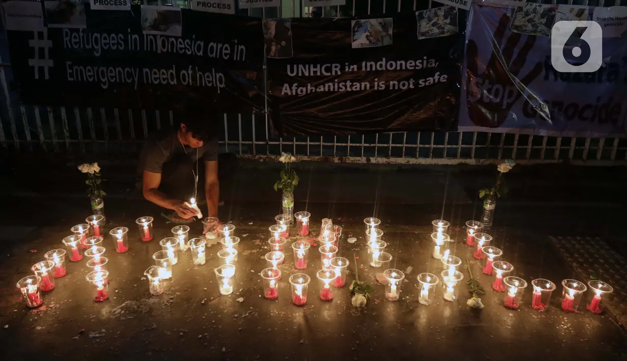 Seorang pencari suaka menyalakan lilin membentuk nama kota di Afghanistan saat aksi keprihatinan yang digelar di depan kantor UNHCR, Jakarta, Selasa (11/5/2021). Mereka prihatin atas peristiwa serangan bom yang menewaskan puluhan siswi di Kabul, Afghanistan. (Liputan6.com/Helmi Fithriansyah)