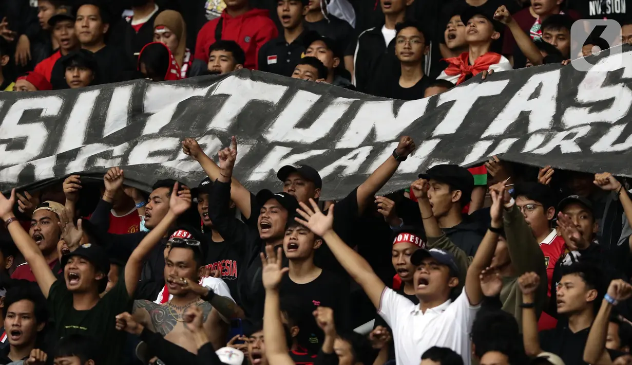 Pendukung timnas Indonesia membentang spanduk bertuliskan “Pengusutan Tuntas” saat menyaksikan laga kualifikasi Grup A Piala AFF 2022 antara Indonesia melawan Kamboja di di Stadion Utama Gelora Bung Karno, Jakarta, Jumat (23/12/2022). Mereka menyuarakan pengusutan tuntas kasus atas Tragedi Kanjuruhan yang terjadi pada awal Oktober 2022 lalu. (Liputan6.com/Helmi Fithriansyah)