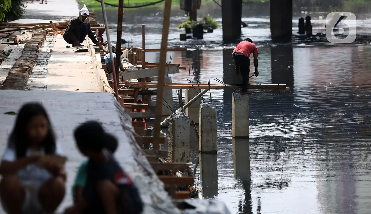Pekerja mengerjakan proyek pembangunan tanggul bantaran Kali Anak Ciliwung di RT 001 RW 008 Ancol, Pademangan, Jakarta Utara, Kamis (19/12/2019). Pembangunan tanggul untuk mencegah amblesnya bantaran sungai seperti pada akhir tahun 2018 lalu. (Liputan6.com/Johan Tallo)
