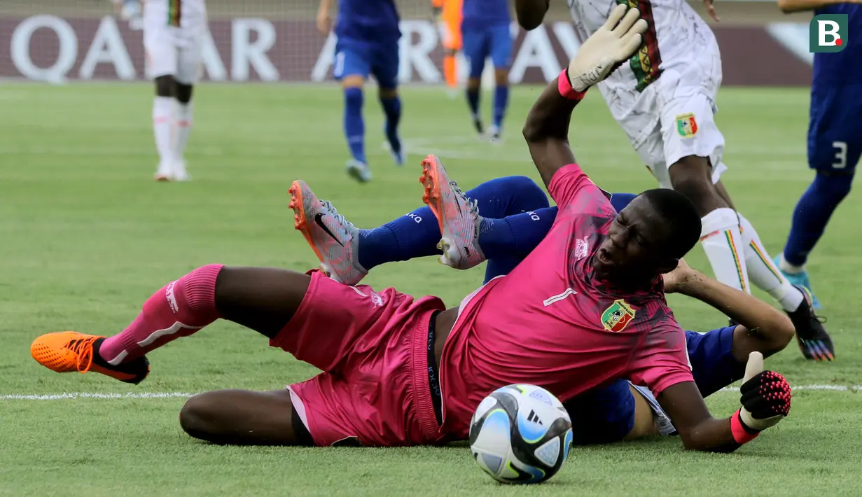 Kiper Timnas Mali U-17, Bourama Kone (kiri), berebut bola dengan pemain Uzbekistan U-17, Amirbek Saidov (kanan), dalam pertandingan penyisihan Grup B Piala Dunia U-17 di Stadion Manahan, Solo. Jumat (10/11/2023). (Bola.com/Arief Bagus)