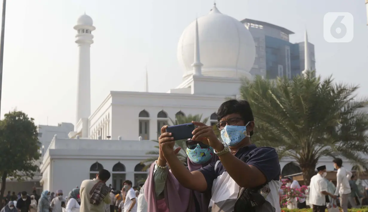 Umat muslim berswafoto usai melaksanakan shalat Idul Fitri 1442 H di Lapangan Masjid Agung Al Azhar, Jakarta, Kamis (13/5/2021). Ribuan umat muslim melaksanakan shalat Idul Fitri 1442 H di Lapangan Masjid Agung Al Azhar dengan menerapkan protokol kesehatan ketat. (Liputan6..com/Helmi Fithriansyah)