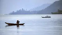 Seorang pria memancing dari perahunya di danau Laut Tawar di Takengon, provinsi Aceh tengah, (1/3). Luas danau Laut Tawar ini kira-kira 5.472 hektare dengan panjang 17 km dan lebar 3,219 km. (AFP Photo/Chaideer Mahyuddin)