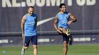 Penyerang Barcelona Luis Suarez (kanan) dan rekan timnya, gelandang Andres Iniesta, mengikuti sesi latihan klub itu di Pusat Latihan Joan Gamper, di Sant Joan Despi, 13 Juli 2015. (AFP PHOTO / JOSEP LAGO)