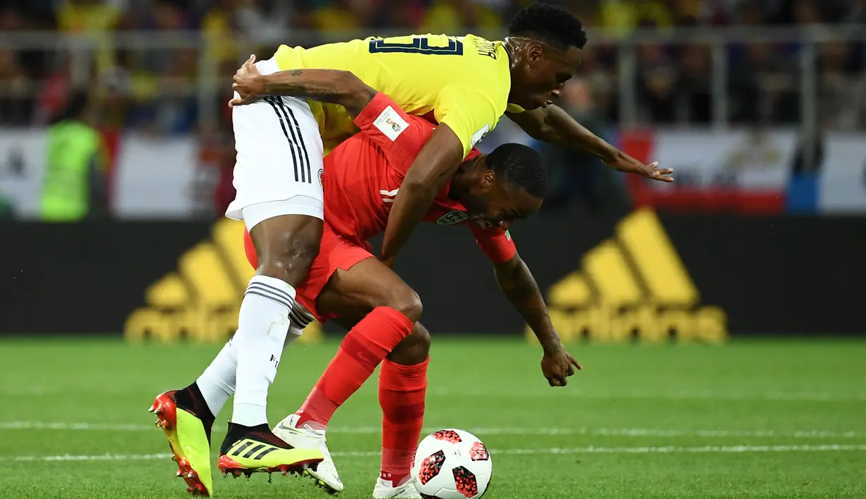 Bek timnas Kolombia, Yerry Mina berebut bola dengan pemain Inggris, Raheem Sterling pada babak 16 besar Piala Dunia 2018 di Stadion Spartak, Selasa (3/7). Selain adu penalti, sebuah kejadian menarik tertangkap kamera pada laga itu. (AFP/FRANCK FIFE)