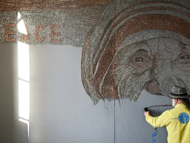 Seniman asal Albania, Saimir Strati saat membuat karya mosaik wajah Suster Teresa menggunakan staples di Museum Pristina, Kosovo (16/11).  Saimir Strati adalah salah satu seniman mosaik yang terkenal di dunia. (AFP/Armend Nimani)