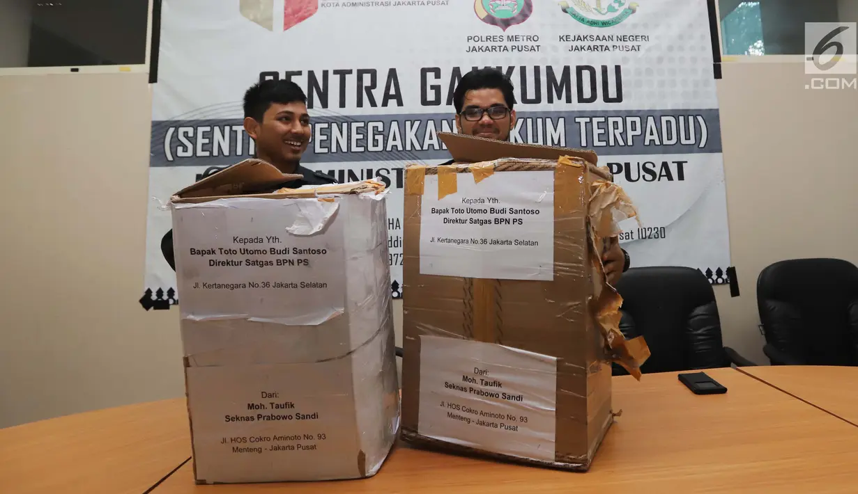 Petugas Bawaslu Jakarta Pusat menunjukkan kardus berisi form C1 Pemilu yang diamankan di Gedung Bawaslu Jakarta Pusat, Senin (6/5/2019). Pihak Bawaslu mengatakan masih akan melakukan investigasi dan pemeriksaan terhadap temuan form C1 dari sejumlah daerah itu. (Liputan6.com/Helmi Fithriansyah)