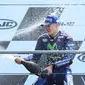 Pembalap Movistar Yamaha dan Tim Yamaha Tech 3, Maverick Vinales dan Johann Zarco saling menyemprotkan sampanye di podium MotoGP Prancis, Minggu (21/5). Vinales menjuarai MotoGP Prancis disusul Zarco yang menempati posisi kedua. (AP Photo/David Vincent)