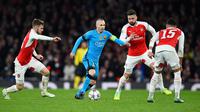 Gelandang Barcelona, Andres Iniesta berusaha membawa bola dari kawalan tiga pemain Arsenal pada leg pertama 16 besar Liga Champions di Stadion Emirates, Inggris (24/2). Barcelona menang atas Arsenal dengan skor 2-0. (Reuters/Dylan Martinez)