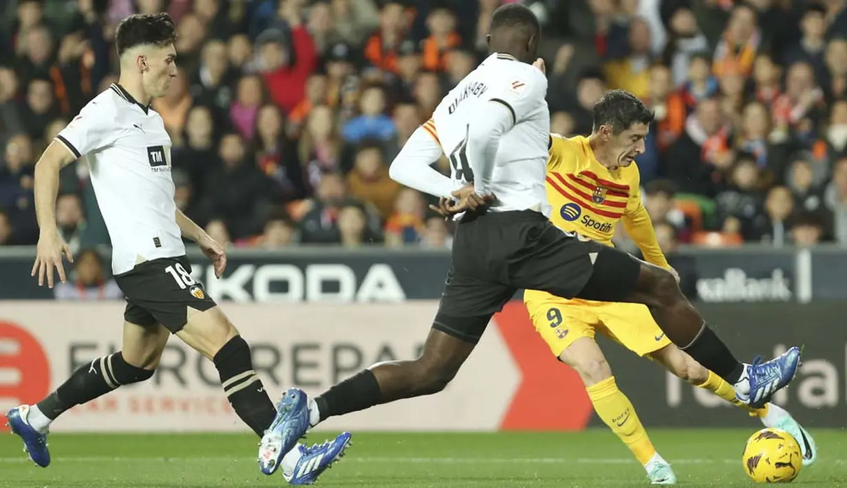 Pemain Barcelona, Robert Lewandowski, berusaha melepaskan tendangan saat melawan Valencia pada laga pekan ke-17 La Liga 2023/2024 di Stadion Mestalla, Minggu (17/12/2023). (AP Photo/Alberto Saiz)