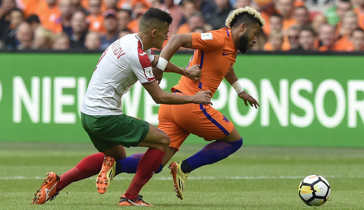 Pemain Belanda, Tonny Vilhena (kanan) melewati adangan pemain Bulgaria, Georgi Kostadinov pada laga grup A kualifikasi Piala Dunia 2018 di Amsterdam, (3/9/2017). Belanda menang 3-1. (AFP/John Thys)