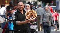 Seorang pedagang Suriah memperlihatkan panekuk tradisional yang dikenal sebagai "Naaem" yang biasa disajikan selama Ramadhan, di Shaqhoor Damaskus pada 28 April 2021. Tahun demi tahun, makanan Ramadhan menjadi lebih hemat di Suriah yang dilanda perang dan ekonomi yang memburuk. (LOUAI BESHARA/AFP)