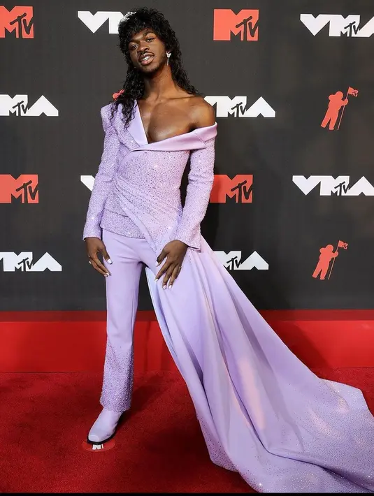 Sedangkan Lil Nas terlihat sempurna dengan jas custom disertai aksen ekor panjang bernuansa ungu karya Versace.
