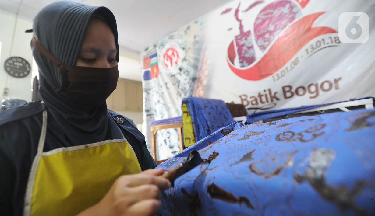Perajin menyelesaikan proses pembuatan batik di  Batik Tradisiku, Bogor, Jawa Barat, Kamis (6/8/2020). Perajin batik mitra binaan Pertamina ini berinovasi dengan membuat motif dan warna baru untuk mengatasi anjloknya penjualan batik sebagai dampak ekonomi wabah corona. (merdeka.com/Arie Basuki)