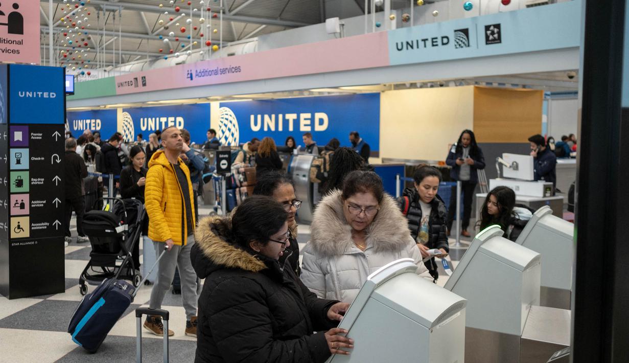 Para pelancong mencari boarding pass dan memasuki pos pemeriksaan keamanan di Terminal 1 Bandara O'Hare pada 12 Januari 2024 di Chicago, Illinois. (Jim Vondruska/Getty Images via AFP)