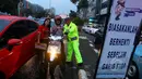 Seorang petugas bersama Pandu Jalan Fullo melakukan sosialisasi tertib berlalu lintas di kawasan perempatan Cideng, Jakarta, Senin (23/2). (Liputan6.com/Johan Tallo)