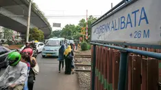 Warga dan pengendara melintas di pintu pelintasan Kereta di Kalibata, Jakarta, (4/12). Pemerintah DKI Jakarta berencana bangun jalan layang atau terowongan di pelintasan-pelintasan sebidang untuk mencegah kecelakaan. (Liputan6.com/Yoppy Renato)