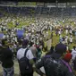 Para suporter berhamburan ke dalam lapangan saat terjadi kerusuhan suporter akibat saling berebut masuk ke dalam Stadion Monumental, Cuscatlan, San Salvador, El Salvador, Sabtu (21/5/2023) waktu setempat untuk menyaksikan laga perempatfinal Divisi Utama El Salvador antara Alianza FC menghadapi Deportivo FAS. (AP Photo/Milton Flores)