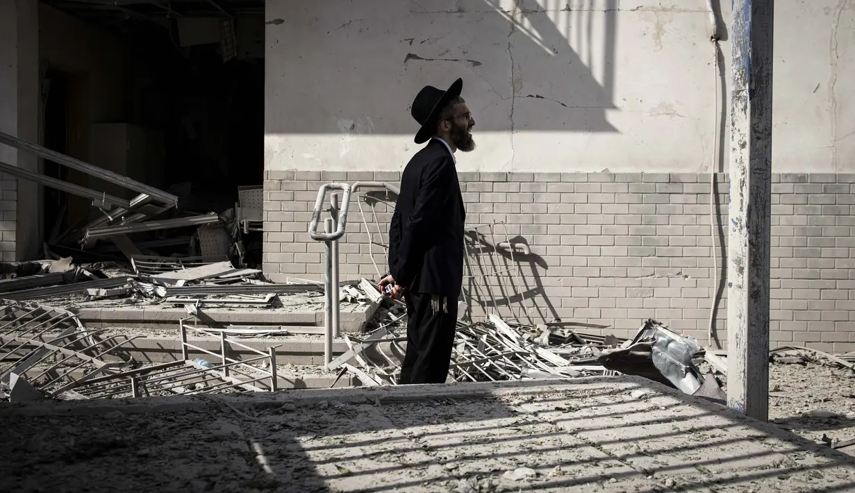 Di Tel Aviv, salah satu rudal disebut mengenai sebuah gedung bertingkat di area Ramat Gan hingga memicu kerusakan struktural. (JOHN WESSELS/AFP)