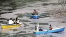 Orang-orang yang memakai masker menikmati mekarnya bunga sakura dari perahu dayung di Tokyo, Senin (29/3/2021). Menyaksikan sakura dari atas perahu dayung sambil menyusuri aliran sungai memberikan pengalaman berbeda. (AP Photo/Koji Sasahara)