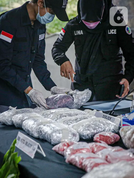 Petugas menata barang bukti terkait upaya penyelundupan narkoba jaringan Malaysia saat rilis di Gedung Bareskrim Mabes Polri, Jakarta, Selasa (30/3/2021). Total barang bukti yang disita ada 42 kilogram lebih narkotika jenis sabu dan 83 ribu butir pil ekstasi. (Liputan6.com/Faizal Fanani)