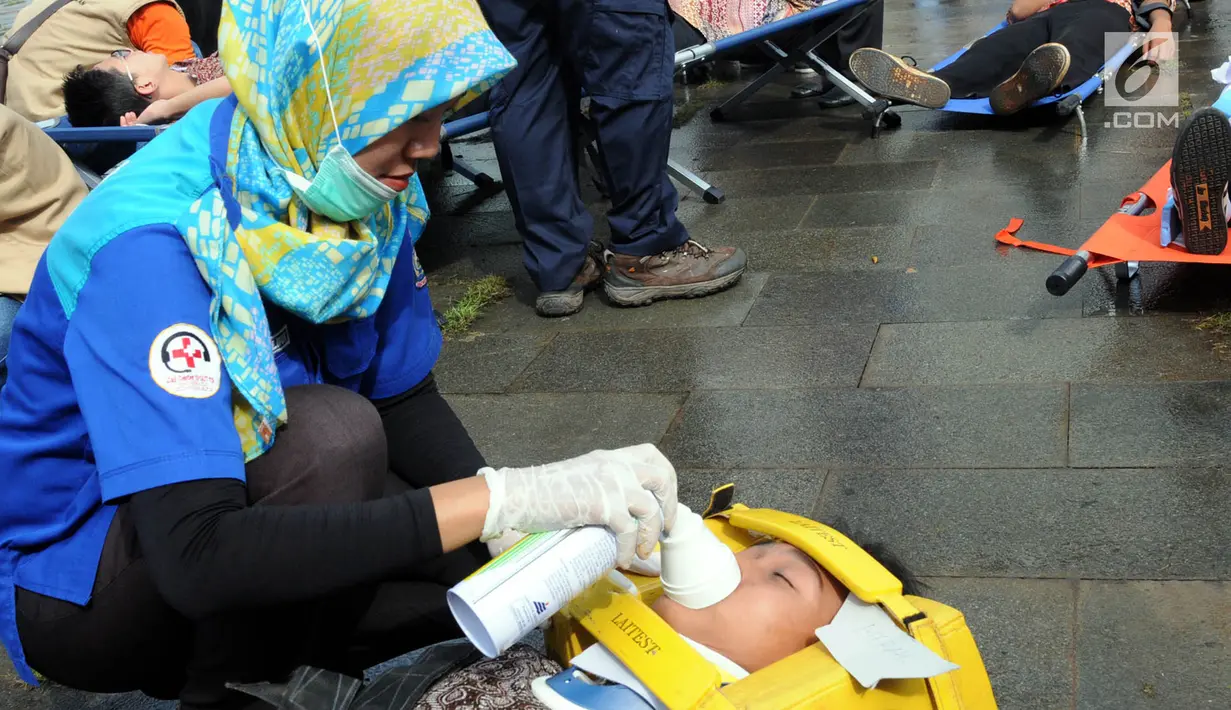 Petugas penyelamat memberi alat bantu napas pada korban saat simulasi penanggulangan kebakaran dan gempa bumi di Balai Kota Tangsel, Banten, Kamis (26/4). Acara diikuti oleh berbagai komponen pemerintah, swasta, dan masyarakat. (Merdeka.com/Arie Basuki)