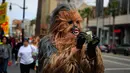 Peniru superhero, Donte mengenakan menghitung uang di Hollywood Boulevard, Los Angeles, 25 Mei 2017.  Hari itu merupakan hari pertama Donte mengenakan kostum karakter film Star Wars, Chewbacca  yang dibelinya sekitar Rp 5 jutat. (AP/Jae C. Hong)