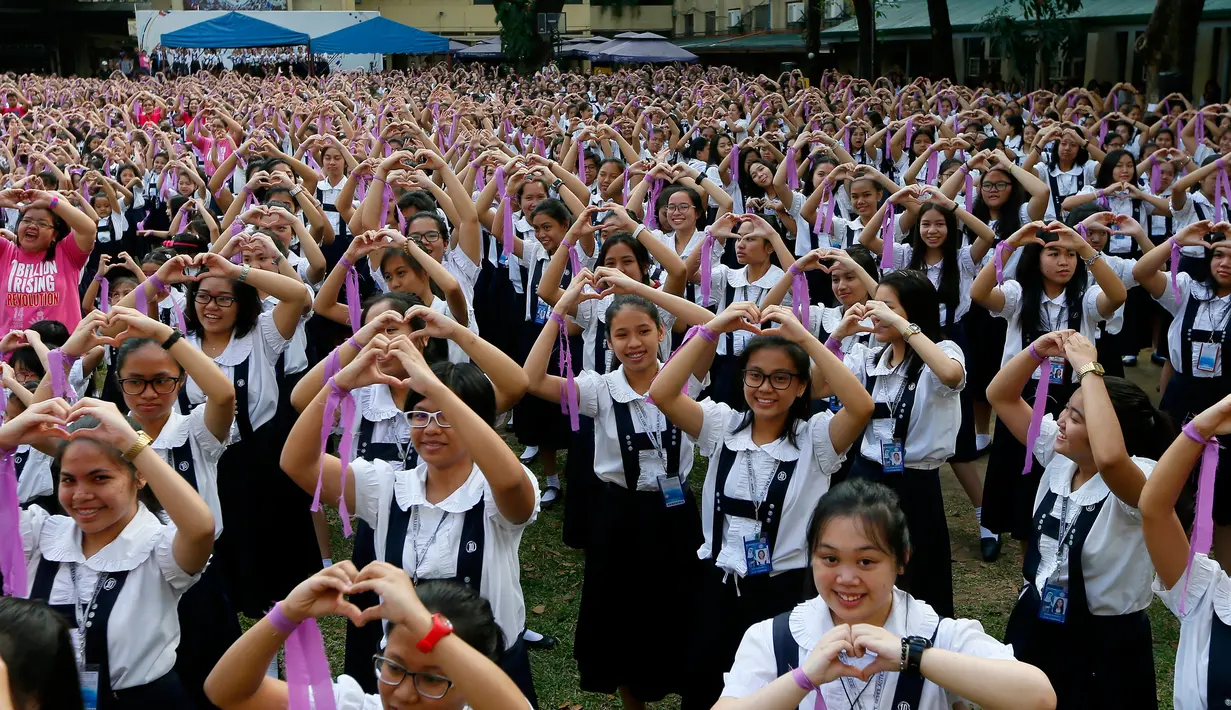 Pelajar dan Mahasiswa membentuk simbol cinta saat merayakan Hari Valentine dengan menggelar tari massal bertajuk "One Billion Rising" di Manila, Filipina, Selasa (14/2). (AP Photo / Bullit Marquez)