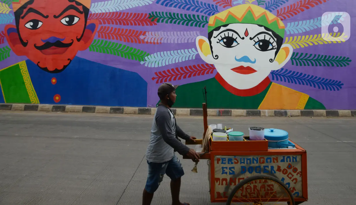 Soerang pedagang melintas di Flyover 'Gaplek' Martadinata yang dipercantik dengan lukisan mural di Tangerang Selatan, Jumat (9/4/2021). Seni mural ini untuk memperindah suasana jalan kota. (merdeka.com/Imam Buhori)