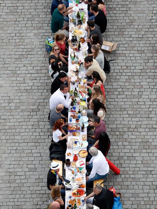 Warga menggelar makan malam di atas meja sepanjang 500 meter di jembatan bersejarah Charles Bridge di Praha, Republik Ceko, Selasa (30/6/2020). Kegiatan itu merupakan perpisahan simbolis yang digelar untuk menandai akhir dari masa krisis virus corona Covid-19 di negara tersebut (AP/Petr David Josek)