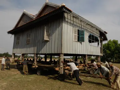 Warga bergotong royong memindahkan rumah di Desa Serey Andet di provinsi Kampong Speu, Kamboja (27/3). Pindah rumah dengan cara tradisional ini bagian dari budaya di Desa Serey Andet. (AP Photo/Heng Sinith)