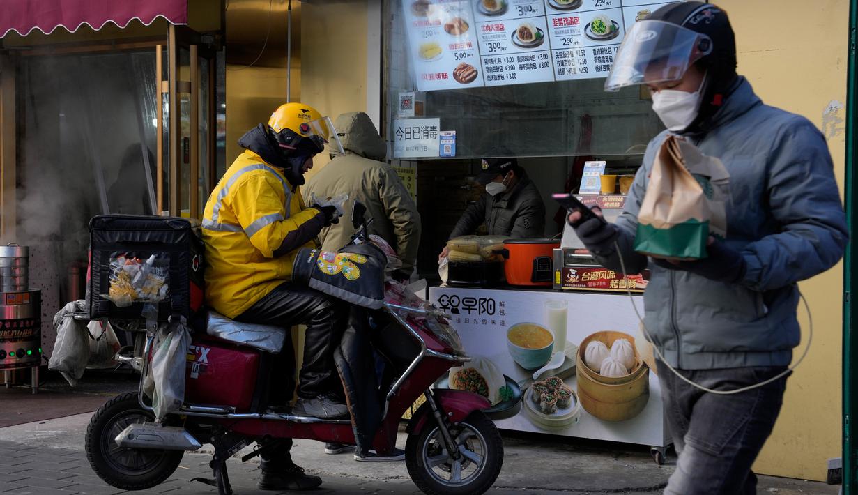 Seorang kurir menyantap sarapannya di sebuah toko di Beijing, China, Kamis (15/12/2022). Seminggu setelah China melonggarkan beberapa tindakan pengendalian COVID-19 yang paling ketat di dunia, ketidakpastian masih ada mengenai arah pandemi di negara dengan jumlah penduduk terpadat di dunia tersebut. (AP Photo/Ng Han Guan)