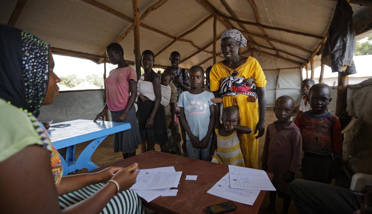 Petugas mendata pengungsi yang baru tiba di sebuah pusat transit pengungsi di Kuluba, Uganda utara, Kamis (8/6). Mereka melarikan diri dari perang saudara di Sudan Selatan yang telah memakan korban puluhan ribu jiwa. (AP Photo / Ben Curtis)