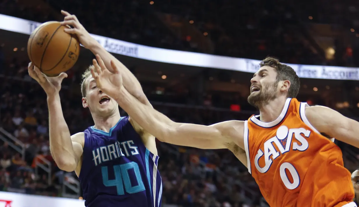 Pemain Charlotte Hornets, Cody Zeller #40 mencoba memasukan bola melewati pemain Cleveland Cavaliers, Kevin Love #0 pada laga NBA di Quicken Loans Arena, (10/12/2016). (AP/Ron Schwane)