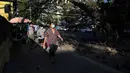 Orang-orang berjalan di sepanjang jalan setapak sehari setelah militer Myanmar merebut kekuasaan, Yangon, Myanmar, Selasa (2/2/2021). Militer Myanmar menahan pemimpin yang terpilih secara demokratis Aung San Suu Kyi dan memberlakukan keadaan darurat satu tahun. (STR/AFP)