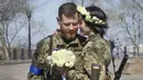 Tentara Ukraina Anastasia dan Vyacheslav berbagi momen mesra sebelum upacara pernikahan mereka di sebuah taman kota di Kiev, Ukraina, 7 April 2022. (AP Photo/Efrem Lukatsky)