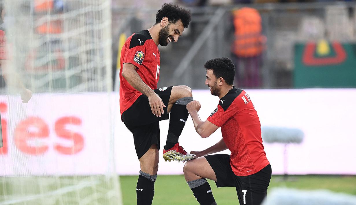 Skor 1-1 di waktu normal membuat laga berlanjut ke babak tambahan dua kali 15 menit dan Mesir sukses mencetak gol pembalik keadaan pada menit ke-100 lewat Trezeguet (kanan). Gol tersebut merupakan kreasi umpan dari Mohamed Salah. (AFP/Charly Triballeau)