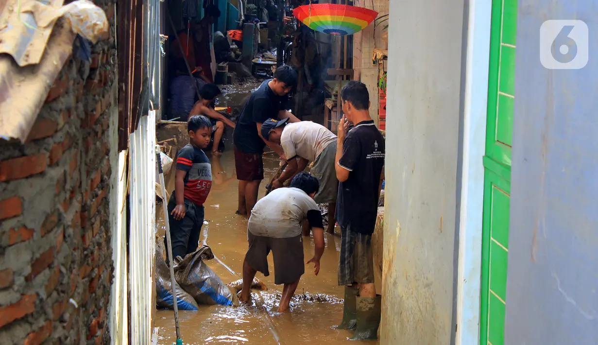Warga kerja bakti membersihkan sisa lumpur dan sampah usai banjir melanda Kampung Melayu, Jakarta, Jumat (3/1/2020). Banjir yang melanda Kampung Melayu menyisakan sisa sampah dan lumpur. (merdeka.com/Magang/Muhammad Fayyadh)