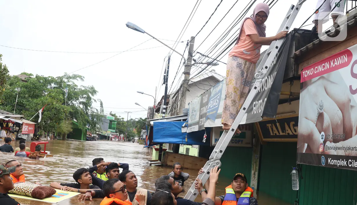 Petugas membantu mengevakuasi warga yang terjebak banjir di perumahan Ciledug Indah, Tangerang, Rabu (1/1/2020). Banjir setinggi dada orang dewasa terjadi akibat meluapnya kali angke. (Liputan6.com/Angga Yuniar)