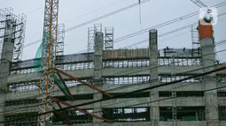 Aktivitas pekerja proyek pembangunan Jakarta International Stadium atau Stadion BMW di kawasan Papanggo, Tanjung Priok, Jakarta, Senin (18/1/2021). Progres pembangunan Jakarta International Stadium atau Stadion BMW ditargetkan rampung pada Oktober 2021. (Liputan6.com/Faizal Fanani)