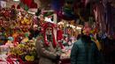 Pedagang menunggu pelanggan di pasar Natal di alun-alun Walikota di pusat kota Madrid, Spanyol (8/12/2021). PM Spanyol mendesak warga untuk "tetap berhati-hati" tentang COVID-19 selama liburan perayaan Natal karena salah satu rumah sakit Spanyol diduga menginfeksi 68 orang. (AP Photo/Manu Fernandez)