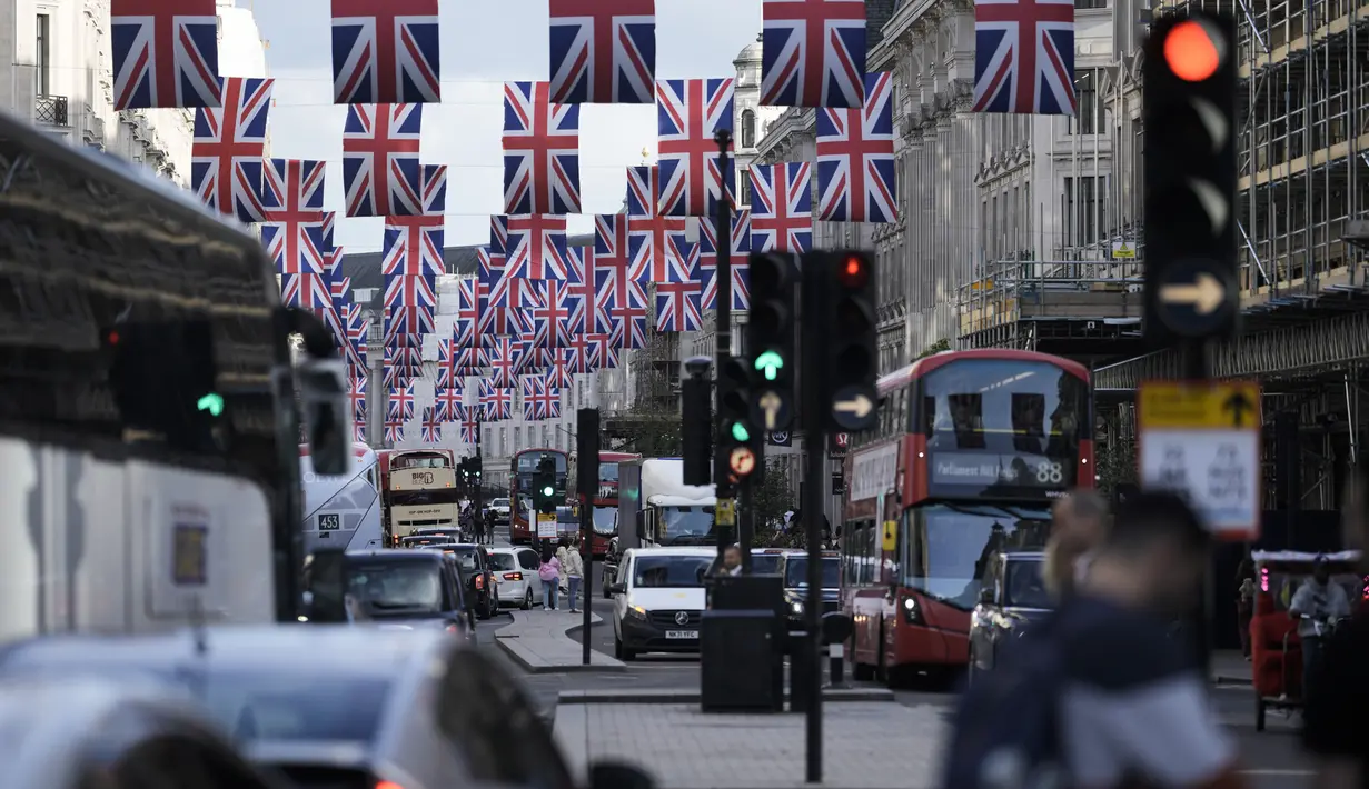 Lalu lintas bergerak melalui Regent Street yang dihiasi di pusat kota London Jumat, 5 Mei 2023. Penobatan Raja Charles III akan berlangsung di Westminster Abbey pada 6 Mei. (AP Photo/Markus Schreiber)