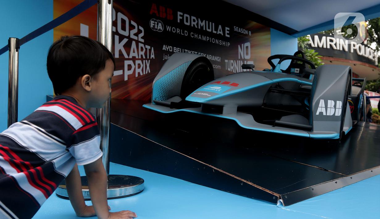 Seorang anak melihat replika mobil Formula E yang dipamerkan di Kawasan Bundaran Hotel Indonesia, Jakarta, Minggu (29/5/2022). Replika mobil balap ramah lingkungan ini dipamerkan untuk mengkampanyekan perhelatan Formula E yang akan digelar 4 Juni mendatang. (Liputan6.com/Helmi Fithriansyah)