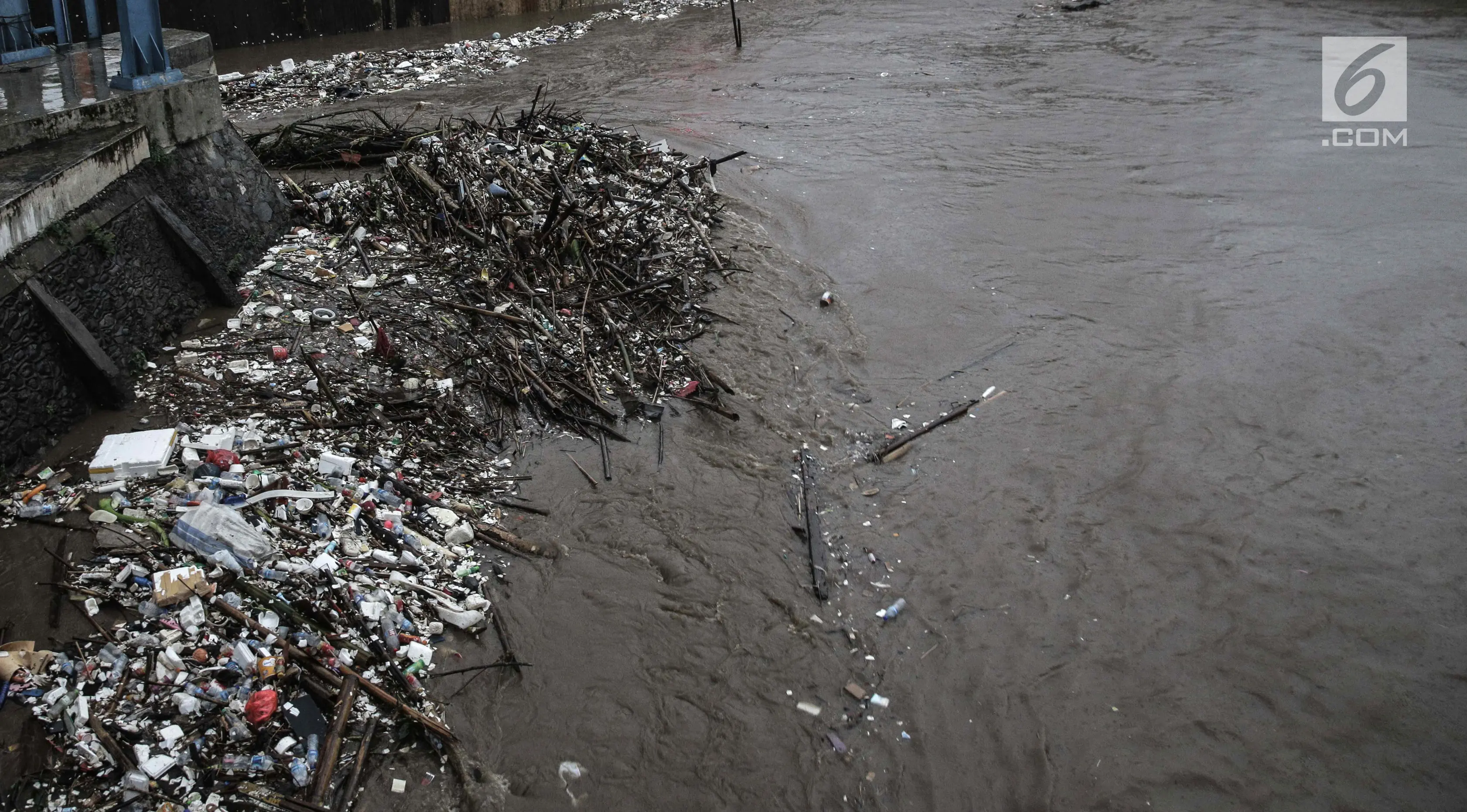 Tumpukan sampah menumpuk di Pintu Air Manggarai, Jakarta, Senin (5/2). Sampah-sampah tersebut terbawa oleh arus banjir kiriman dari Bogor. (Liputan6.com/Faizal Fanani)