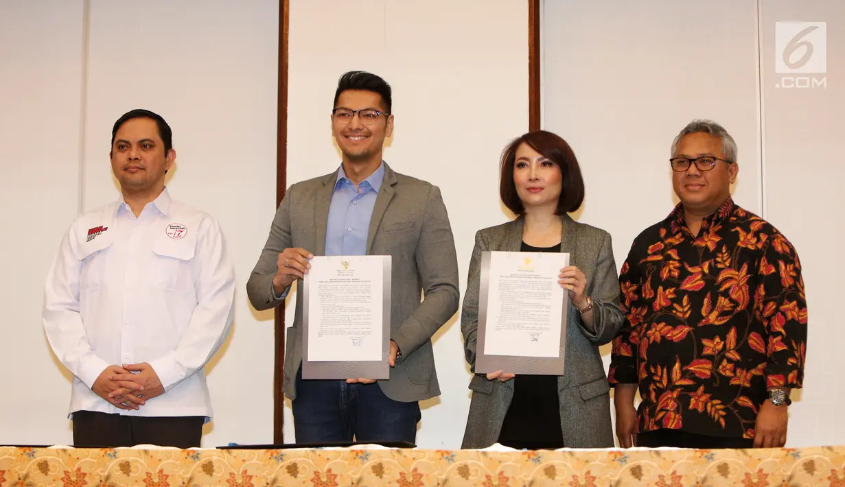 Dua moderator debat keempat Pilpres 2019 ditemani Ketua KPU Arief Budiman memperlihatkan surat pakta integritas usai penandatanganan di Jakarta, Rabu (27/3). Penandatanganan pakta integritas ini merupakan bentuk komitmen menjaga independensi dan integritas debat. (Liputan6.com/Johan Tallo)
