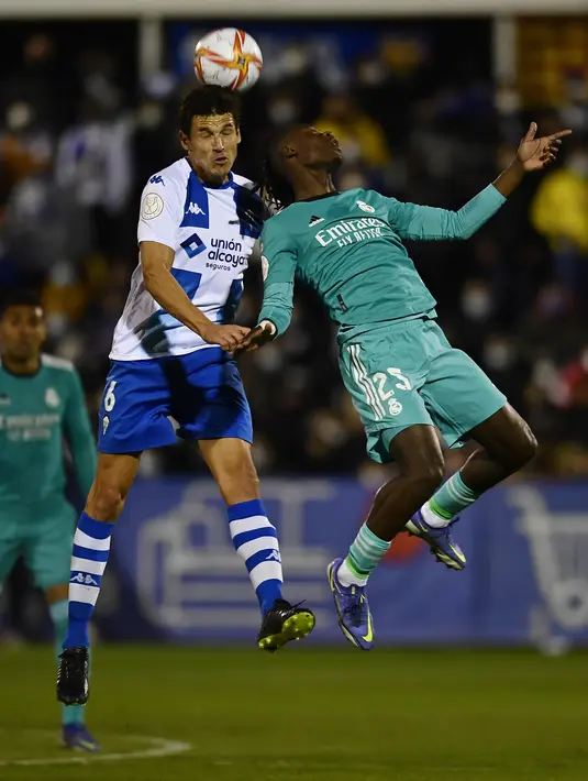 Gelandang Alcoyano, Fran Miranda melompat saat bersaing dengan gelandang Real Madrid Camavinga pada babak 32 besar Copa del Rey di Stadion El Callao, Alcoy, Kamis (6/1/2022) dini hari WIB. Real Madrid mengalahkan tim divis tiga Spanyol, Alcoyano dengan skor 3-1. (AP Photo/Jose Breton)