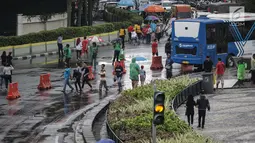 Sejumlah warga melakukan aktivitas saat kegiatan rutin hari bebas kendaraan bermotor atau car free day (CFD) dikawasan Bunderan HI, Jakarta, Minggu (4/2). Warga tetap melanjutkan aktivitasnya walaupun gerimis mengguyur. (Liputan6.com/Faizal Fanani)