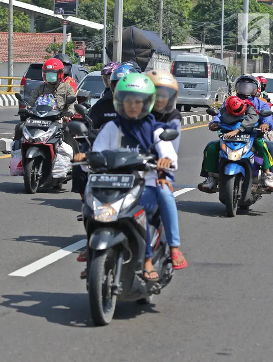 Pemudik sepeda motor melintas di Jalur Pantura, Jawa Barat, Minggu (2/6/2019). Sejumlah pemudik sepeda motor terpantau mengabaikan keselamatan dengan membawa barang bawaan dan penumpang melebihi kapasitas. (Liputan6.com/Herman Zakharia)