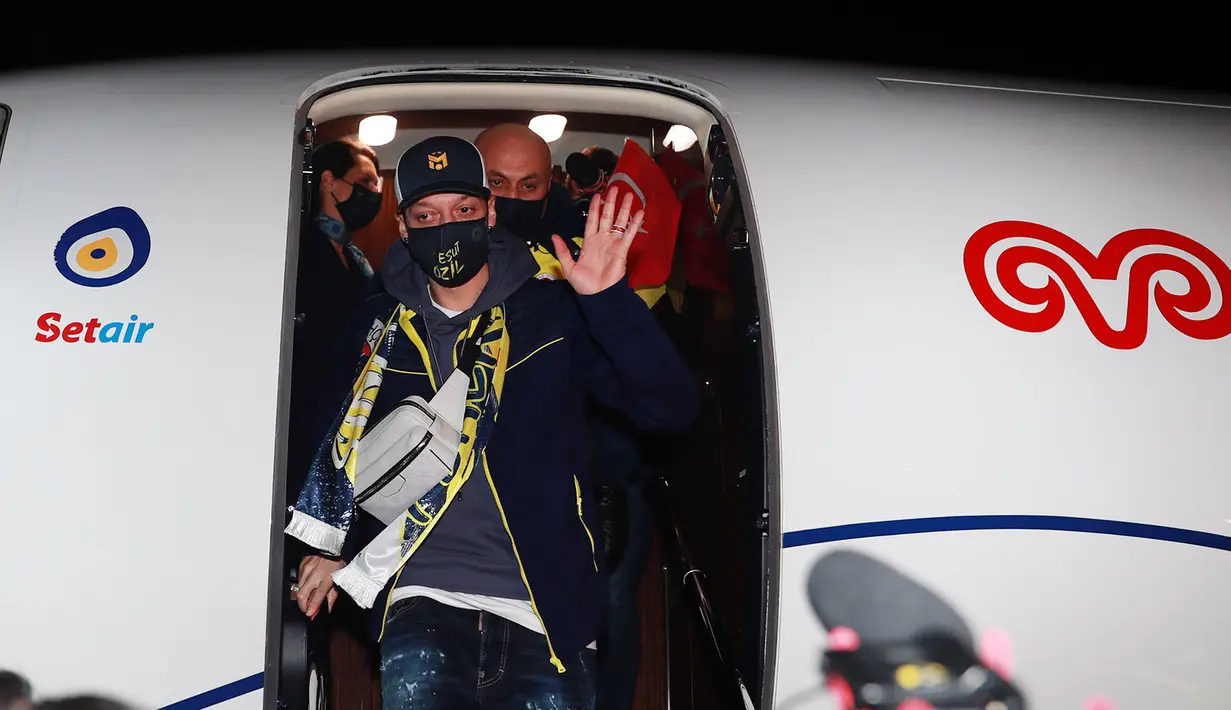 Gelandang Jerman, Mesut Ozil melambaikan tangan setibanya di Bandara Ataturk di Istanbul (18/1/2021). Ozil dihapus dari skuad Arsenal karena mengomentari perlakuan pemerintah Tiongkok terhadap masyarakat Muslim Uighur. (AFP/Fenerbahce.Org)