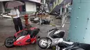 Seorang pria memeriksa sepeda motor yang jatuh akibat angin kencang Topan Soudelor di Taipei, Taiwan, (8/8/2015). Empat orang tewas akibat peristiwa angin kencang Topan Soudelor dan hujan deras.  (REUTERS/Pichi Chuang)