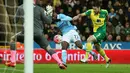Pemain Manchester City, Kelechi Iheanacho melakukan tembakan kearah gawang saat dihadang pemain Norwich City, Russell Martin pada laga Babak ketiga Piala FA di Stadion Carrow Road, Norwich, Sabtu (9/1/2016). (Reuters/Alex Morton)